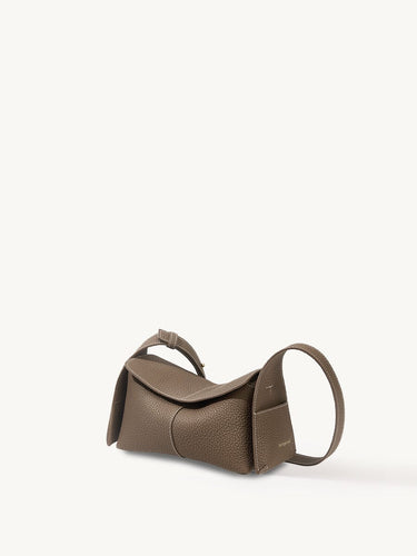 Mini Drippy Roof Bag in taupe pebbled leather with white stitching and a curved strap.