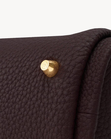 Mini Song Bag in burgundy full-grain leather with gold hardware detail.
