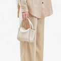 Ivory Mini Song Bag crafted from textured full-grain leather with gold hardware.