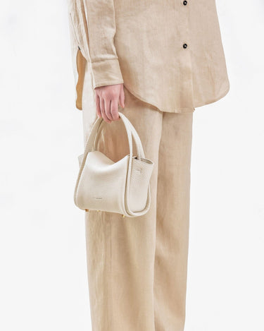Ivory Mini Song Bag crafted from textured full-grain leather with gold hardware.