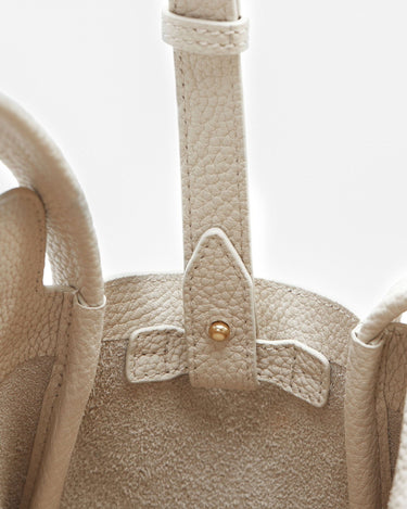 Ivory leather Mini Song Bag interior detail with gold stud closure and textured full-grain leather.