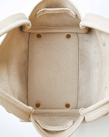 Interior view of ivory Mini Song Bag, full-grain leather lining, structured base with metal feet.