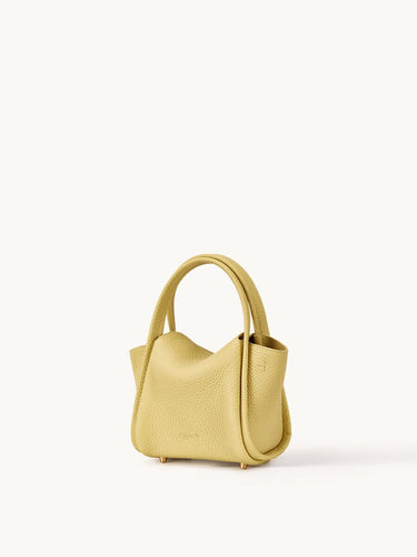 Mini Song Bag in lemon yellow pebbled full-grain leather with folded sides and dual top handles.
