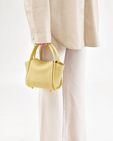 Lemon Mini Song Bag in pebbled leather with dual top handles and subtle embossed branding.