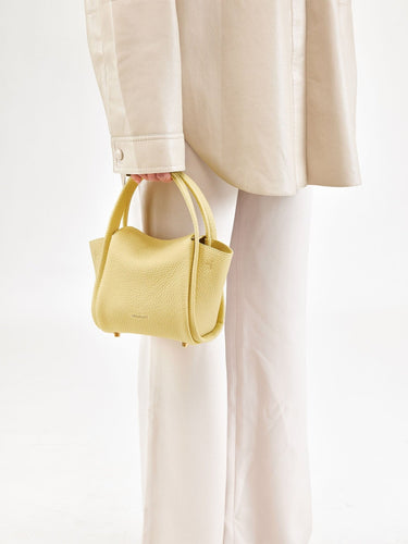 Lemon Mini Song Bag in pebbled leather with dual top handles and subtle embossed branding.