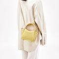 Lemon Mini Song Bag made of pebbled leather, with a structured top handle and a crossbody strap.