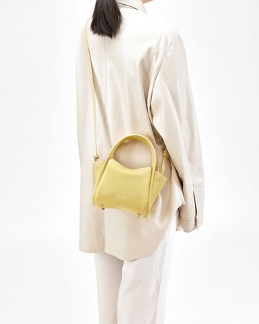 Lemon Mini Song Bag made of pebbled leather, with a structured top handle and a crossbody strap.