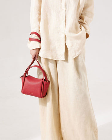 Mini Song Bag in Lucky Red textured leather, with gold hardware. Stylish seasonal bucket bag.