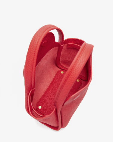 Red pebbled leather Mini Song Bag interior, showing spacious design and golden snap closures.