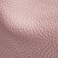 Close-up of pink full-grain leather with a textured pebble grain for the Mini Song Bag.