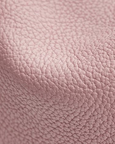 Close-up of pink full-grain leather with a textured pebble grain for the Mini Song Bag.