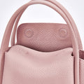 Pink full-grain leather Mini Song Bag with top handles and textured exterior.