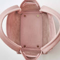 Pink mini bucket bag with pebbled leather interior and exterior, showing the open top and handles.