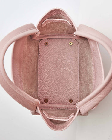 Pink mini bucket bag with pebbled leather interior and exterior, showing the open top and handles.