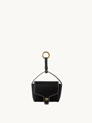 Black vegetable-tanned leather Mini Yore AirPods case with white stitching and gold hardware.