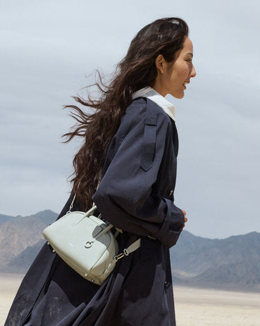 Mini Yore Bowling Bag in Celeste carried by a woman in a desert setting. Features full-grain leather and silver hardware.
