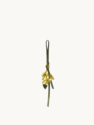 Osmanthus Charm keychain with yellow leather petals and green strap.