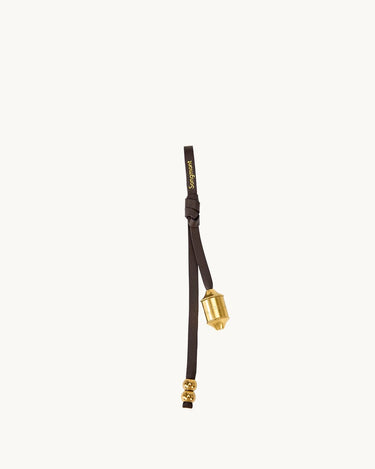 Sandal brown leather prayer wheel charm with gold hardware and "Songmont" logo.