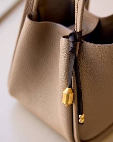 Sandal leather Prayer Wheel Charm with gold engraved pendant and double bead detail.