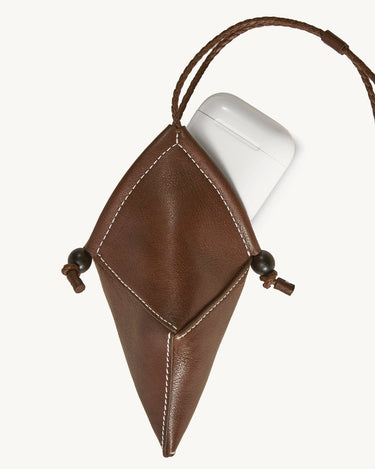 Prism Airpods Case in sandal brown leather with white stitching and wooden beads.