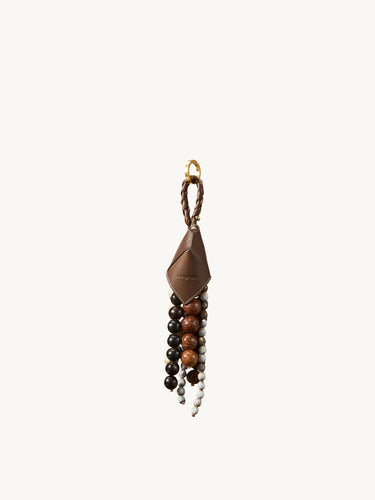 Songmont Prism Seed Charm accessory with brown leather, diverse beads, and gold hardware