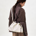 Small Gather Bag Set in Cloud, a cream leather tote with drawstring closure and white strap.