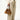 Ochre suede small gather bag set with adjustable straps, held by a person in a cream distressed cardigan and linen pants.