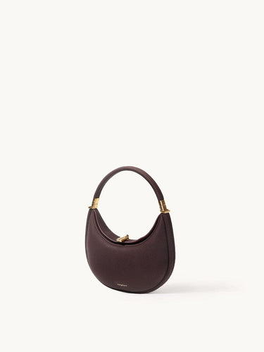 Small Luna Bag in burgundy full-grain leather with gold-tone hardware and adjustable strap.