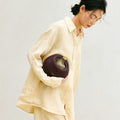 Woman holding the burgundy Small Luna Bag, featuring its rounded shape and textured leather.