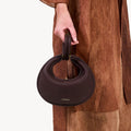 Small Luna Bag in burgundy full-grain leather with a unique crescent shape and gold-tone hardware.