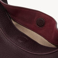 Small Luna Bag in Burgundy, showing the interior with a magnetic closure and textured full-grain leather.