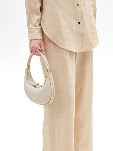 Ivory Small Luna Bag with gold hardware, textured leather, and crescent shape