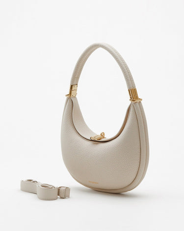 Small Luna Bag in ivory full-grain leather with gold hardware and adjustable strap. Versatile for shoulder or crossbody wear.