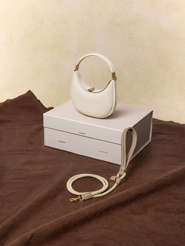 Small Luna bag in ivory full-grain leather with braided pet leash in cream apricot.