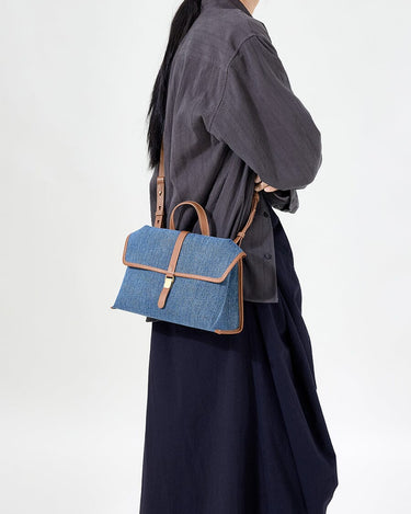 Small Shan Satchel Bag in denim with tan leather trim and gold buckle.