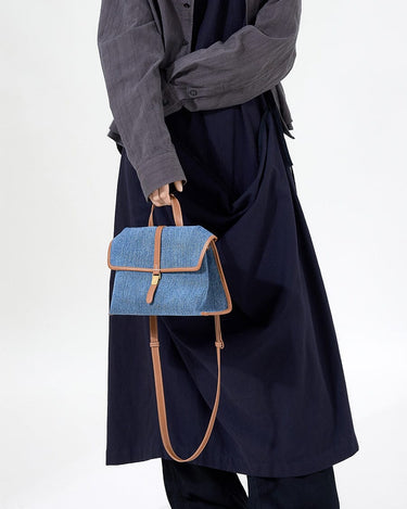 Small Shan Satchel Bag in blue denim with tan leather trim and strap.