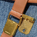 Small Shan Satchel Bag tan leather strap with gold clasp and Songmont logo on blue denim