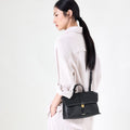 Small Shan Satchel Bag in Onyx, featuring vegetable-tanned leather, adjustable strap, and gold hardware.