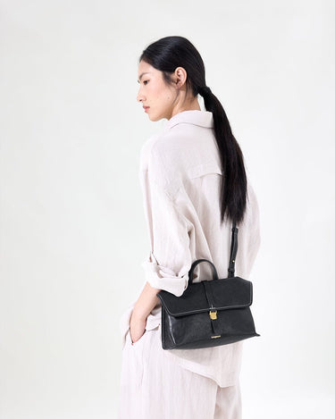 Small Shan Satchel Bag in Onyx, featuring vegetable-tanned leather, adjustable strap, and gold hardware.