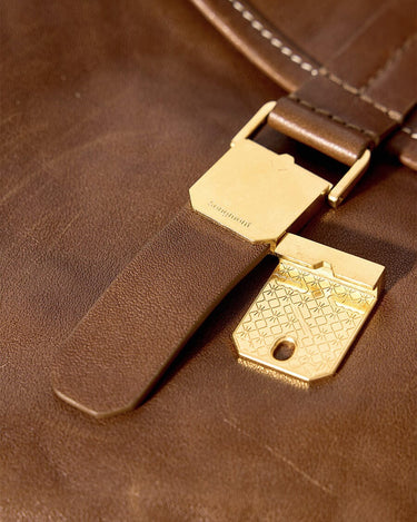 Small Shan Satchel Bag in brown leather with gold hardware and engraved latch