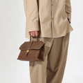 Small Shan Satchel Bag in Sandal brown vegetable-tanned leather with gold buckle detail.