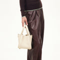 Small off-white full-grain leather song bag with magnetic closure and gold feet.