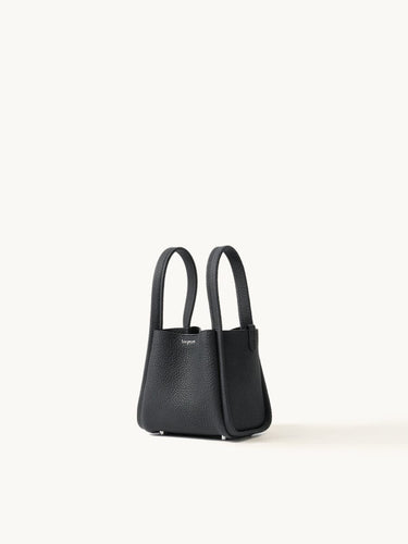 Small black full-grain leather Song bag with top handles and magnetic closure.