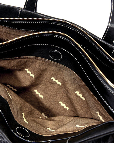 Interior of black Small Yore Duffle Bag with patterned lining and visible compartments.