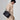 Small Yore Duffle Bag in Onyx, a textured black leather bag with white stitching worn over the shoulder.