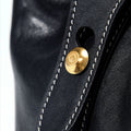 Small Yore Duffle Bag in onyx black leather with white stitching and gold logo closure.