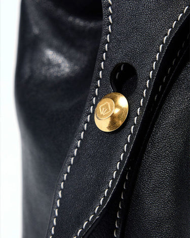 Small Yore Duffle Bag in onyx black leather with white stitching and gold logo closure.