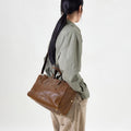 Small Yore Duffle Bag in Sandal brown leather, adjustable strap, brass hardware, detailed stitching. Versatile travel bag.