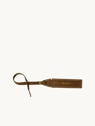 The Yore Luggage Tag in vegetable-tanned leather with "Songmont" embossed.