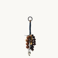 Wish Seeds Charm accessory made with natural Bodhi seeds in brown and white, attached to a blue cord with a metal ring.